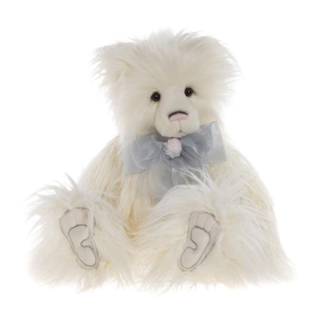 Cream coloured Charlie Bears Charmaine plush bear sitting front facing with blue satin bow