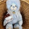 Gaynor Charlie Bears Charlie Bears Gaynor plush bear sitting inside a wicker basket with tags attached