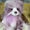 Keeper of Secrets Close-up of Charlie Bears Keeper of Secrets with fluffy purple and cream fur sitting in a wicker basket