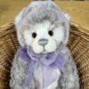 Plush Collection Meghan Close-up of Charlie Bears Meghan plush bear sitting in basket with lilac bow