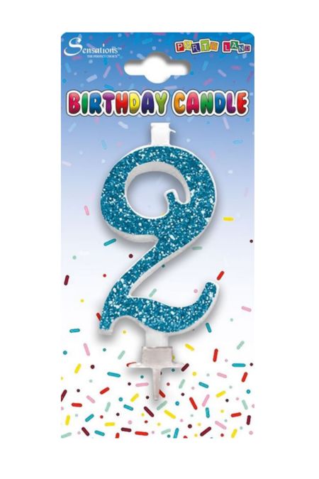Blue glitter number 2 birthday candle from Sensations on packaging with confetti background