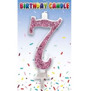 Pink glitter birthday cake candle shaped as number 7 on a party-themed card
