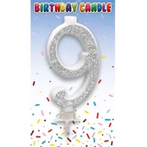 Silver glitter number 9 birthday candle with holder on colourful party background
