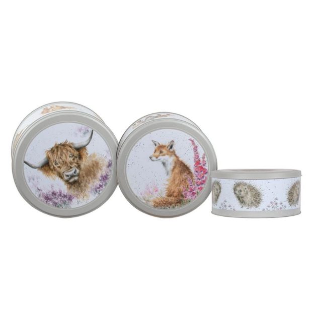 Top view of three nestling cake tins with animal illustrations including a highland cow and a fox