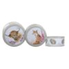 Top view of three nestling cake tins with animal illustrations including a highland cow and a fox