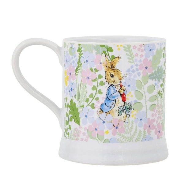 Peter Rabbit Mug Side view of ceramic mug featuring Peter Rabbit holding a radish amidst delicate floral design
