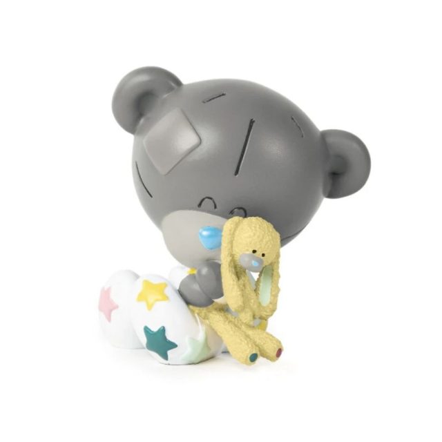 Tiny Tatty Teddy figurine wearing white baby grow with colourful stars clutching a yellow bunny