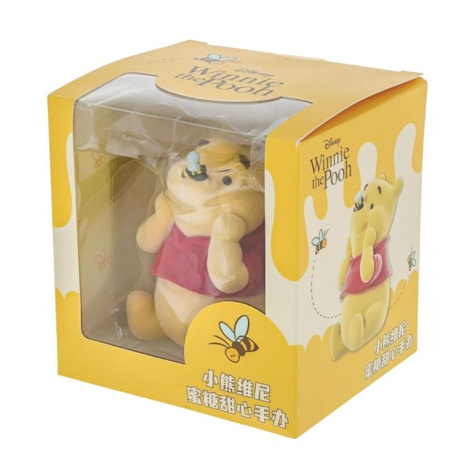 Flocked Winnie the Pooh figurine boxed with yellow packaging featuring honey design