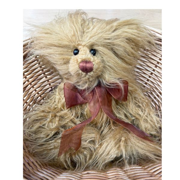 Close-up view of Charlie Bears Tater Tot showing dark brown organza bow and expressive eyes