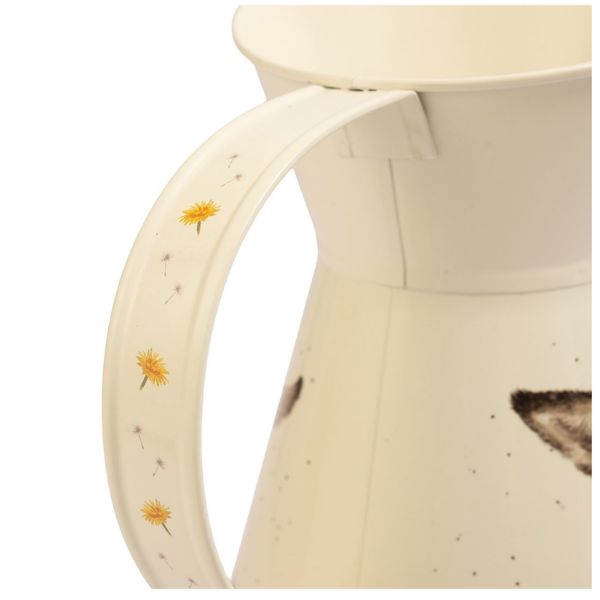 Close-up of cream jug handle decorated with yellow flowers and dandelion seeds