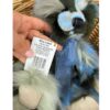 CB256135O Close-up of Charlie Bears Miss Liddell teddy bear holding label with product details