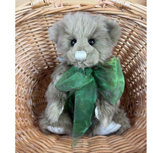 Charlie Bears Mr Baggins plush bear sitting in wicker basket showing front view with green bow