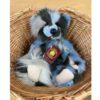 Miss Liddell Charlie Bears Miss Liddell plush bear with label seated in a wicker basket