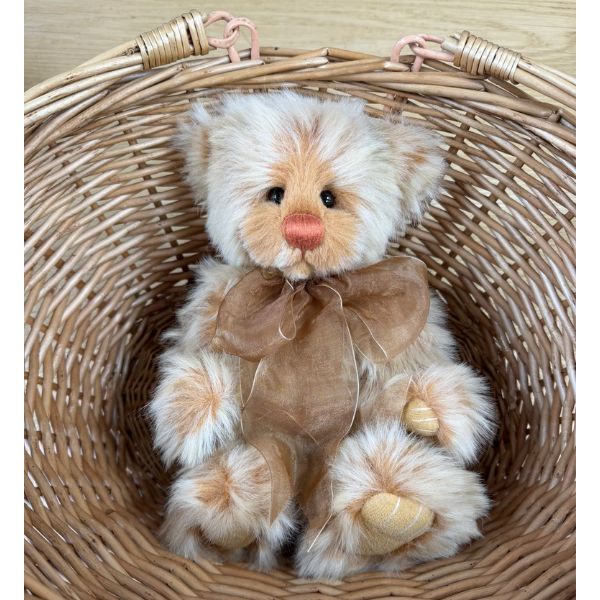 Charlie Bears Monday teddy bear seated inside woven basket showing full body and bow