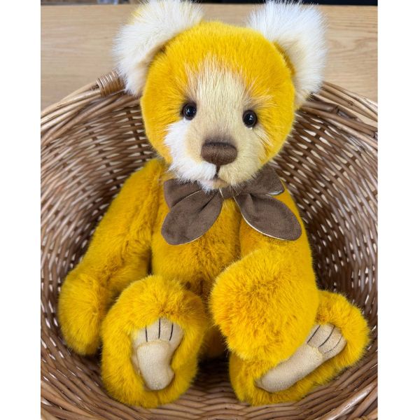 Charlie Bears Mrs Jones bear nestled in a wicker basket showing soft white inner ears and contrasting muzzle