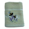 Beige kitchen tea towel with embroidered bees, daisies, and purple flowers