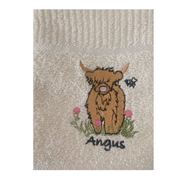 Detailed close-up of embroidered Angus cow on cream Riggs tea towel